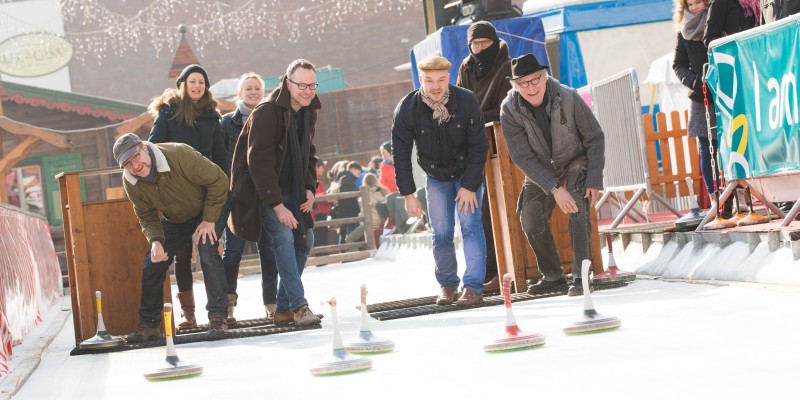 Männer und Frauen beim Eisstockschießen bei Essen.On Ice.