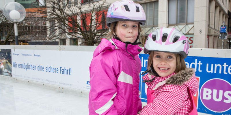 Zwei Kinder auf Eislauffläche bei Essen.On Ice.