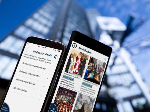 Foto: Essen To Go App auf Handy vor Rathaushintergrund
