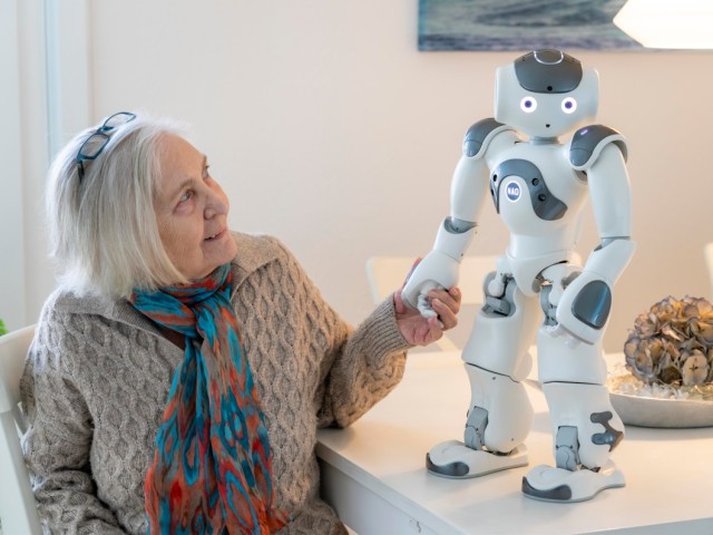 Foto: Frau hält die Hand eines Roboters