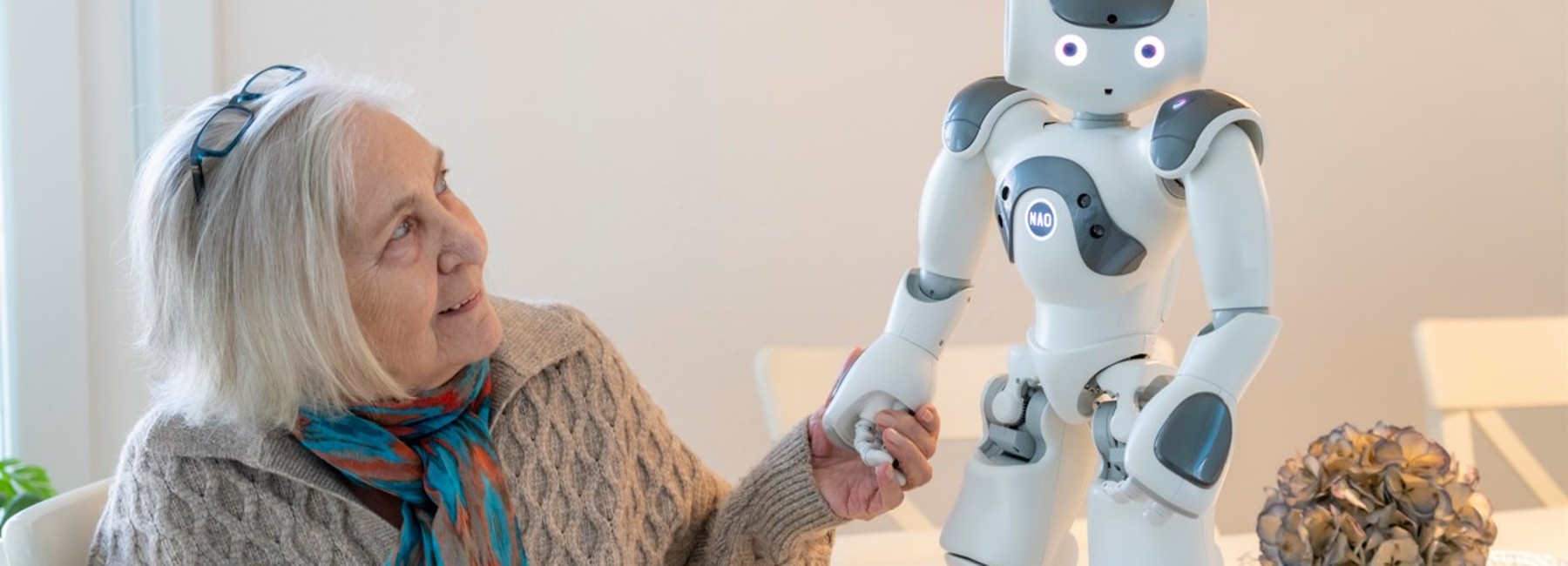 Foto: Frau hält die Hand eines Roboters
