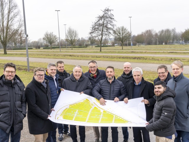 Foto: Unterstützende Personen halten den Bauplan am Bauort