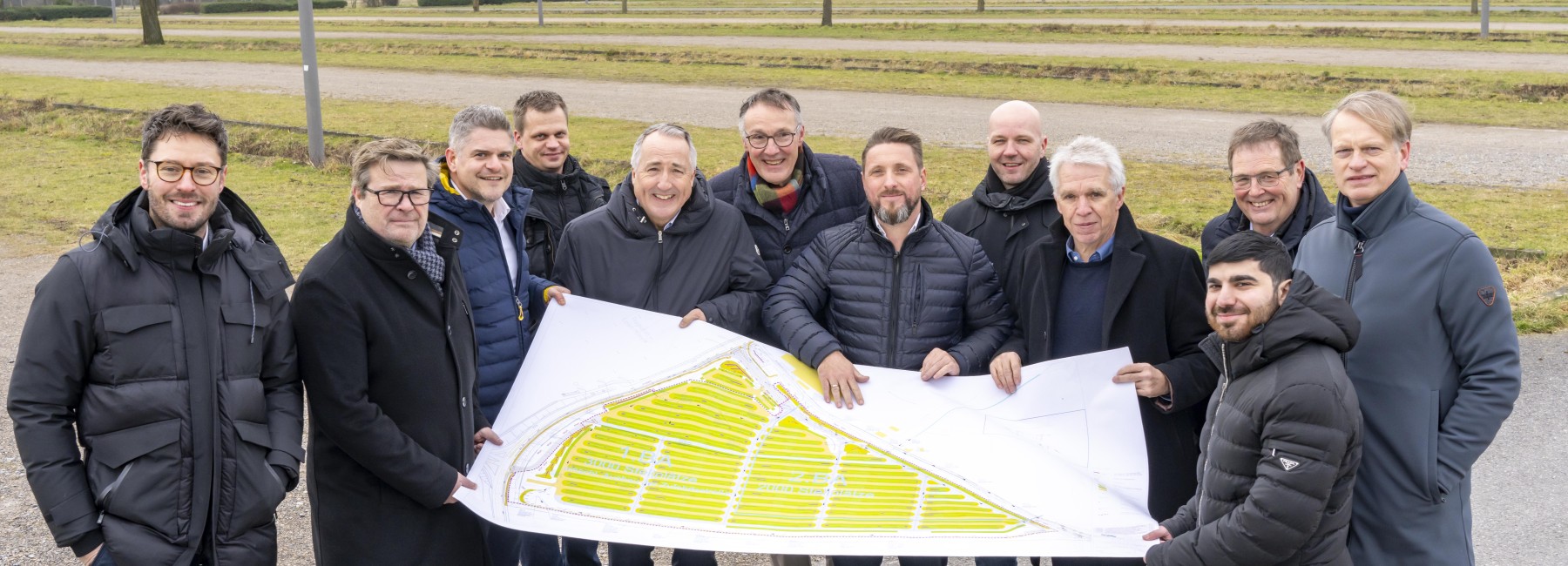 Foto: Unterstützende Personen halten den Bauplan am Bauort