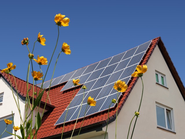 Foto: Hausdach mit Photovoltaik-Anlage bei Sonnenschein