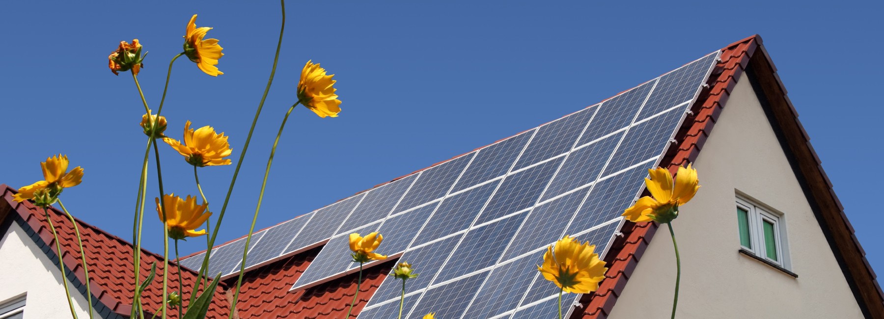 Foto: Hausdach mit Photovoltaik-Anlage bei Sonnenschein