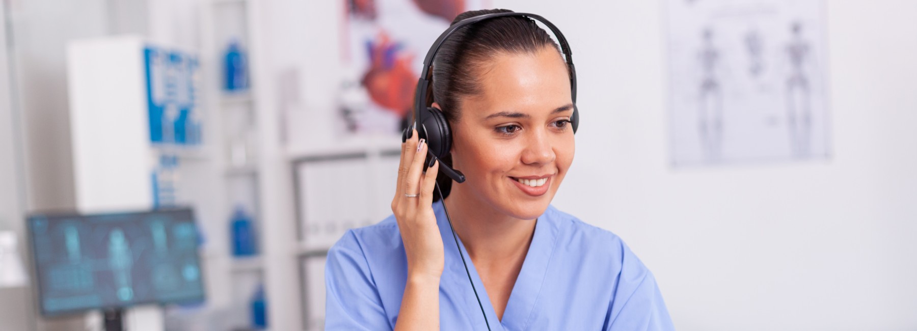 Foto: Medizinische Fachkraft mit Headset vor einem Notebook