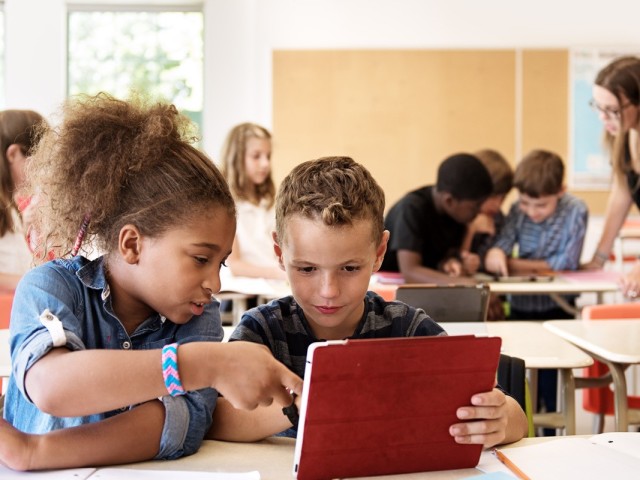 Foto: Schülerinnen und Schüler mit digitalen Mediengeräten