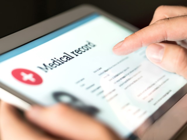 Foto: Person hält ein Tablet auf dem die Worte "Medical Record" zu sehen sind