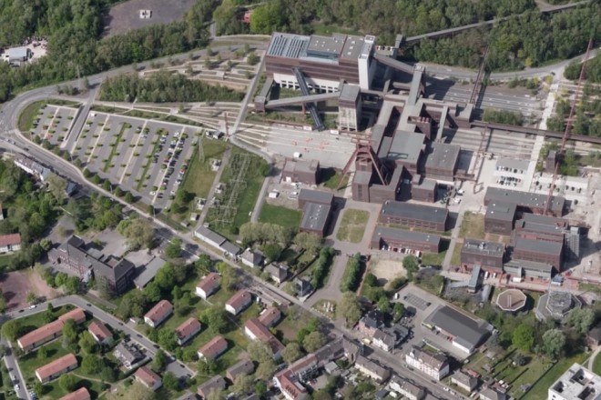 Foto: Luftbild einer Industrieanlage mit umliegenden Gebäuden und Parkplätzen 