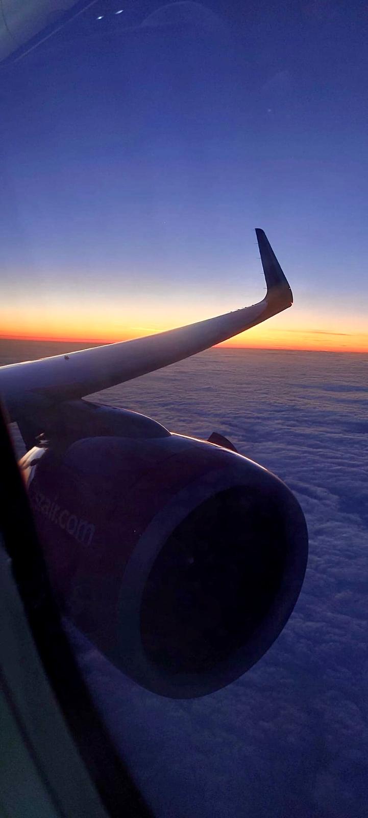 Sonnenaufgang über den Wolken bei einem Flug
