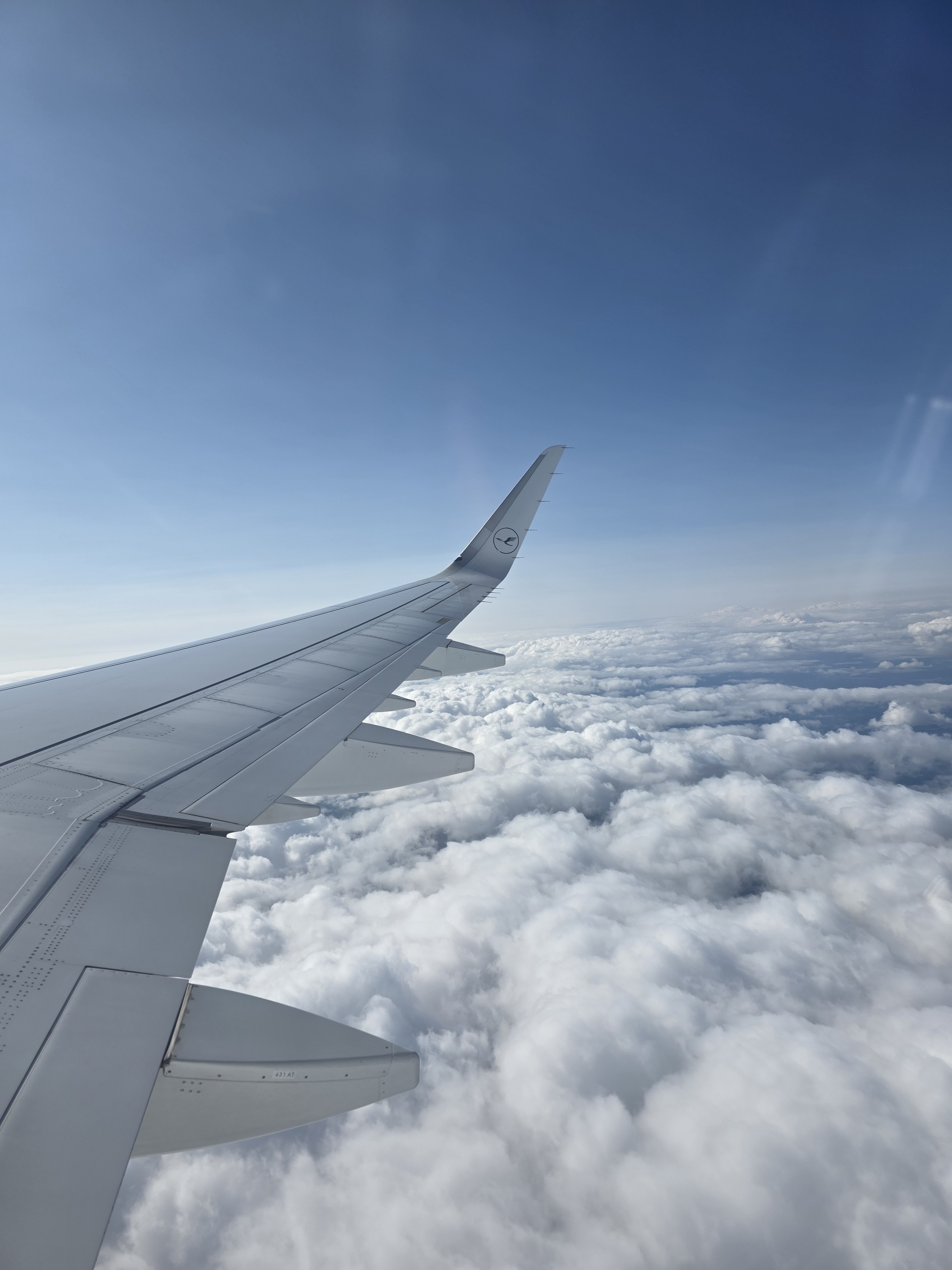 Blick aus den Flugzeugfenster auf die Tragfläche und die Wolken