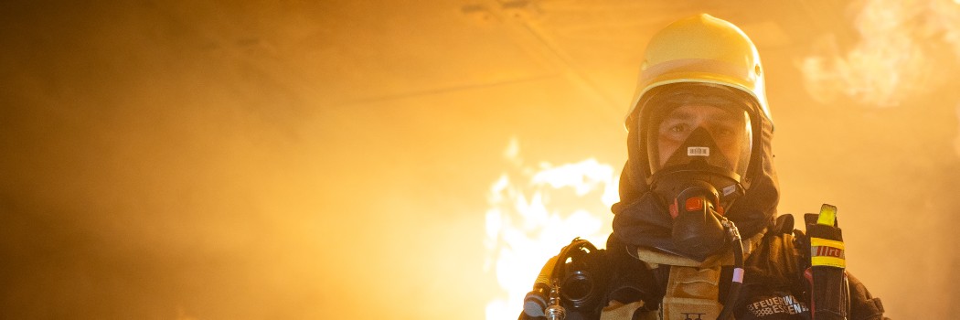 Foto: Ein Feuerwehrmann in Ausrüstung kommt aus dem Feuer