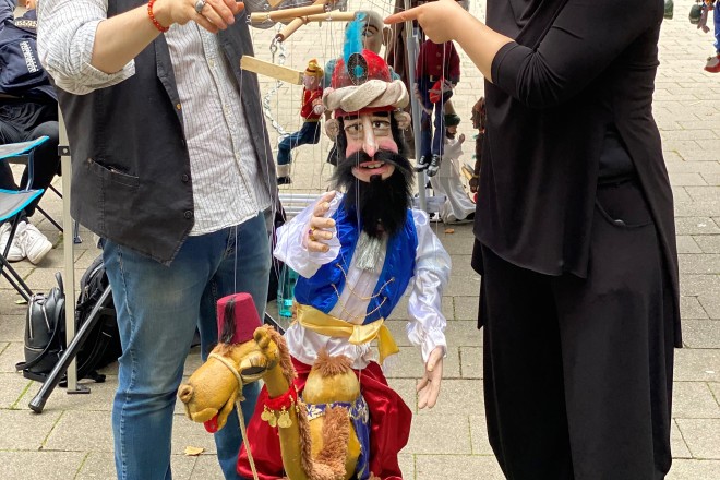 ein Mann und eine Frau halten Marionetten