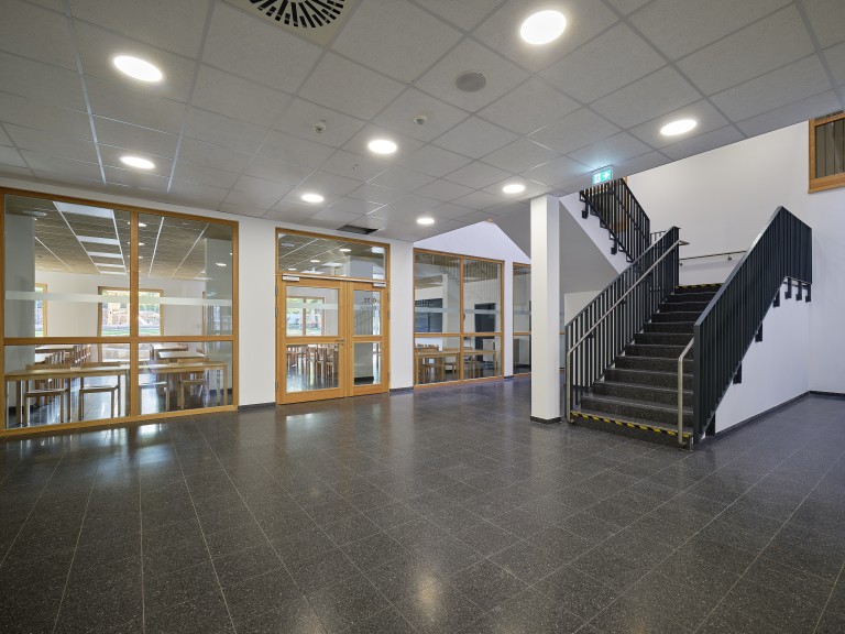 Das Foto zeigt die Mensa und das Treppenhaus im Gebäude des Holzmodulneubaus Rosastraße 80.
