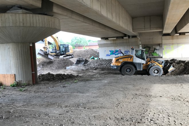 Foto: Zwei Bagger auf Baustelle unterhalb eines Brückenbauwerkes