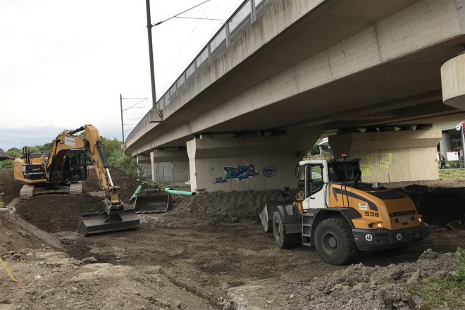 Foto: Zwei Bagger auf Baustelle neben Brückenbauwerk