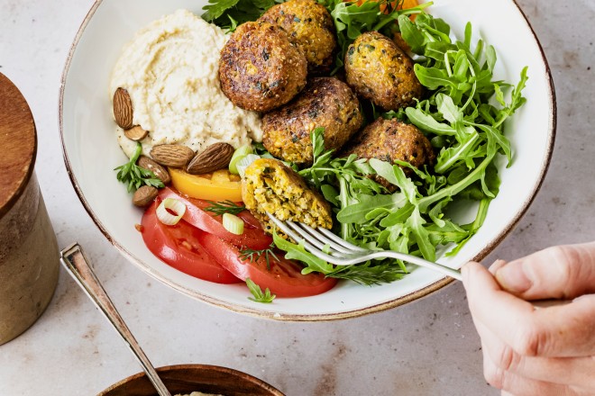 Abgebildet ist eine Bowl mit Hummus und Falafeln