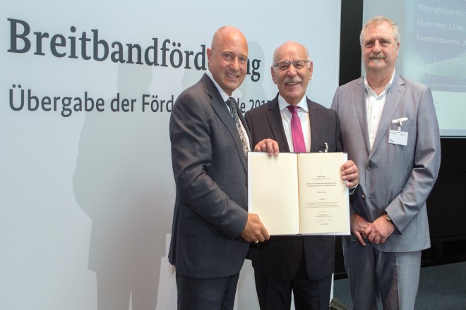 Rainer Bomba, Staatssekretär im Bundesministerium für Verkehr und digitale Infrastruktur überreicht den Förderbescheid für superschnelles Breitband an Bürgermeister Rudolf Jelinek (Mitte) und Uwe Breder, Breitbandkoordinator der Essener Wirtschaftsförderungsgesellschaft mbH (EWG). 