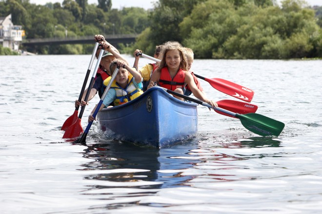 Kinder paddeln im Kanu auf dem Wasser.