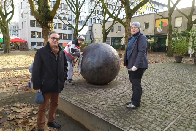 Das Kunstwerk "Ein leichtes Spiel" mit seinen Stahl-Elementen am Salzmarkt wird gereinigt. Kulturdezernent Muchtar Al Ghusain (links), und Mitarbeiterinnen der Restaurationsfirma "Zur Schmiede" Clara Buchegger (Mitte) und Anna Windmüller (rechts).