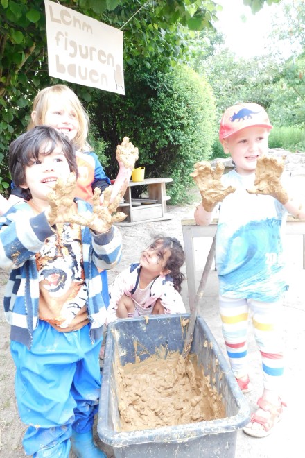 Die Kinder beim Bauen von Lehmfiguren. 