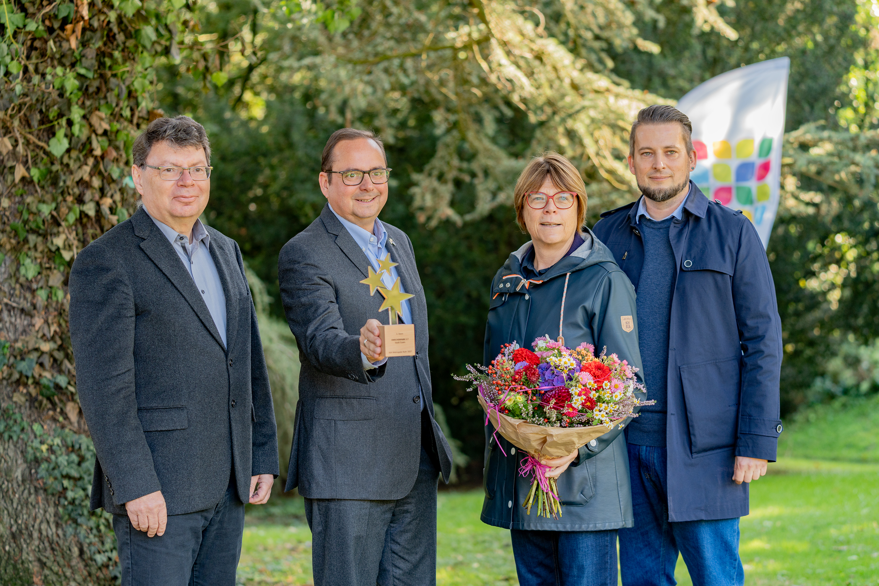 Foto: Gruppenfoto zur Verleihung des dritten Sterns für das Projekt "Emscherpark 2.7 Bunt in die Zukunft – im Grünen aktiv" (v.l.n.r.): Horst Fischer, Geschäftsführung IGA Metropole Ruhr gGmb, Oberbürgermeister Thomas Kufen, Simone Raskob, Geschäftsbereichsvorständin für Umwelt, Verkehr und Sport der Stadt Essen, Mattis Ricken, Fachbereichsleitung Grün und Gruga. 