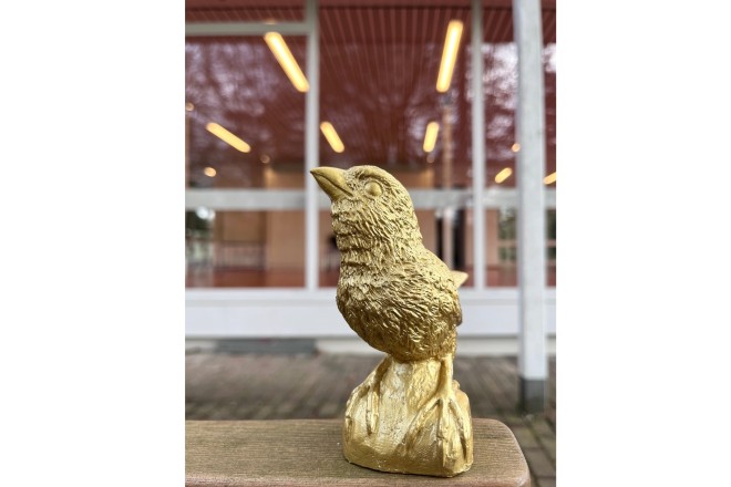 Foto: Abbildung eines goldenen Spatzen. 