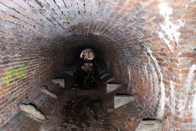 Sonderform eines Deckungsgrabens aus Ziegelsteinen mit Resten der Sitzb&auml;nken an den W&auml;nden.