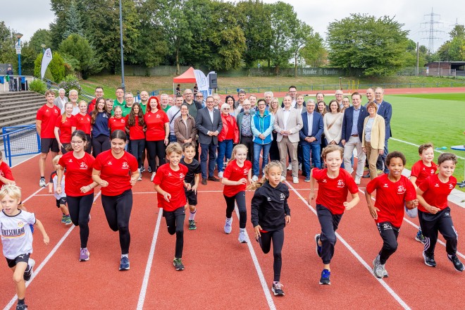 Foto: Oberb&uuml;rgermeister Thomas Kufen gemeinsam mit Vertreterinnen*Vertretern der Vereine, des Rates und der Verwaltung bei der Er&ouml;ffnung der Bezirkssportanlage (BSA) Oststadt in Freisenbruch nach umfangreichen Sanierungsarbeiten. 